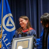 President and Awardee smile while holding award